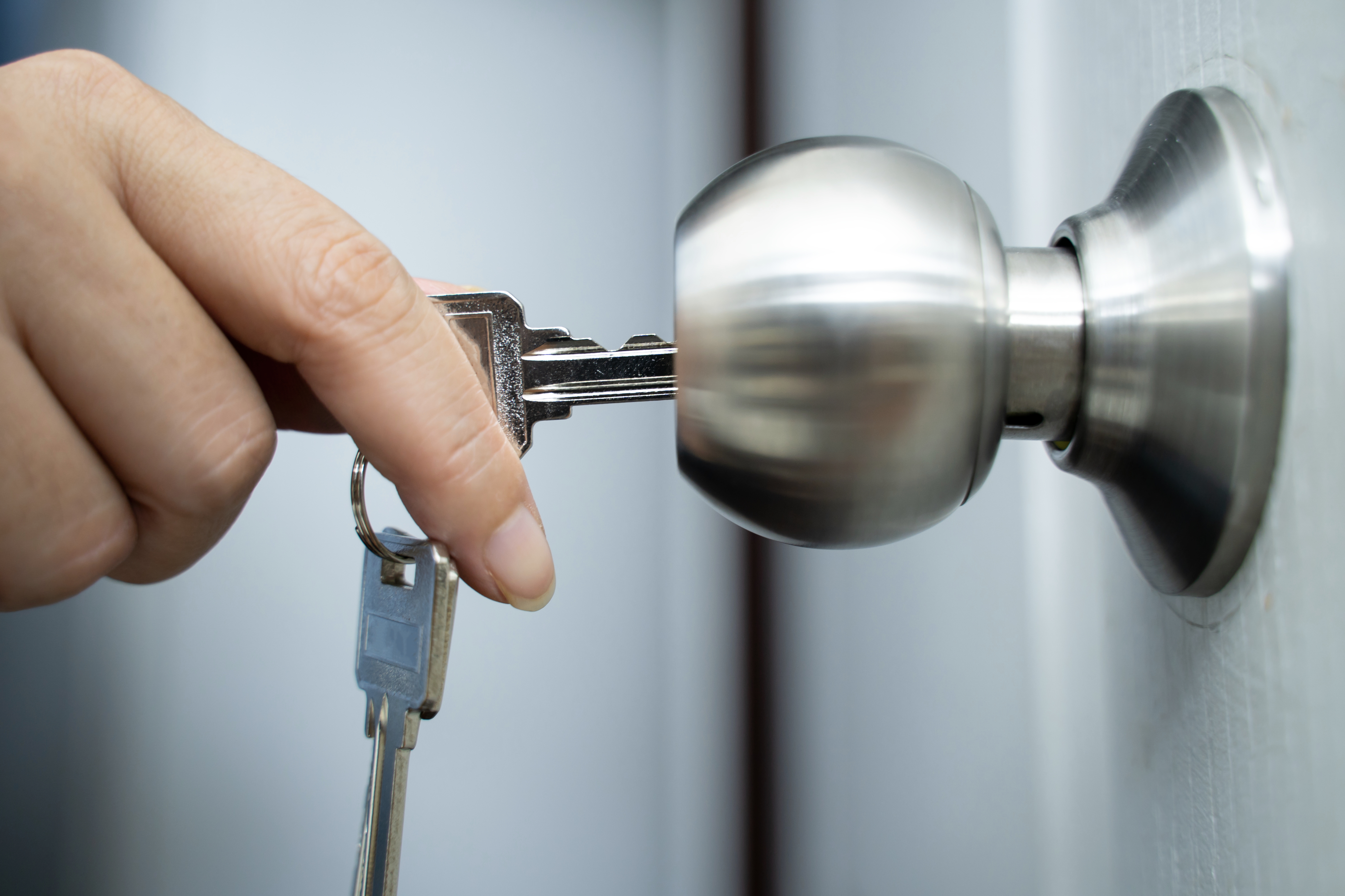 Hand inserting a cardinal into a doorway lock