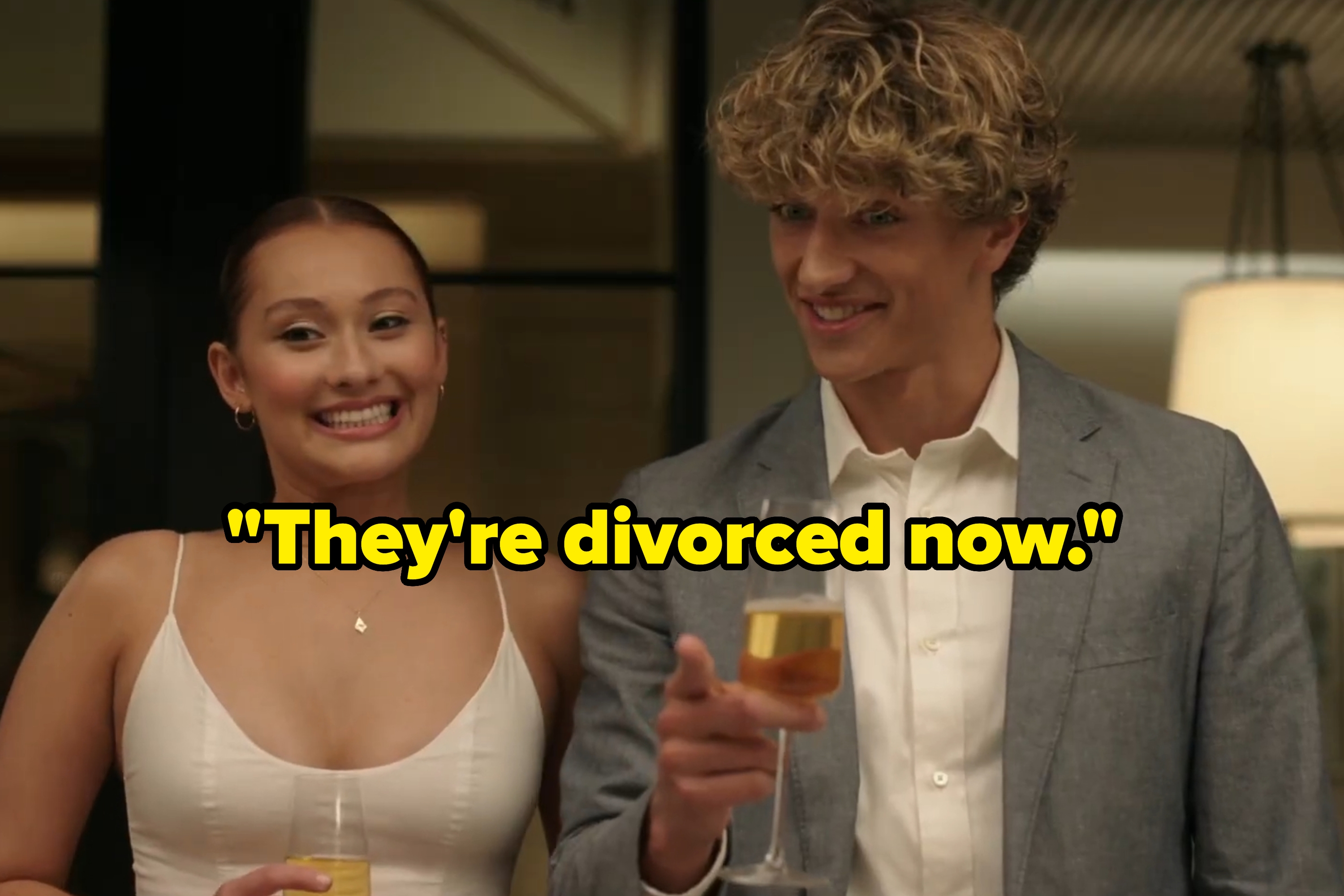 "The Summer I Turned Pretty" Belly and Jeremiah smiling forcibly and holding champagne glasses at rehearsal dinner with text: "They're divorced now"
