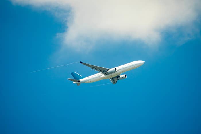 Airplane flying successful  a wide   entity  with a cloud, leaving contrails
