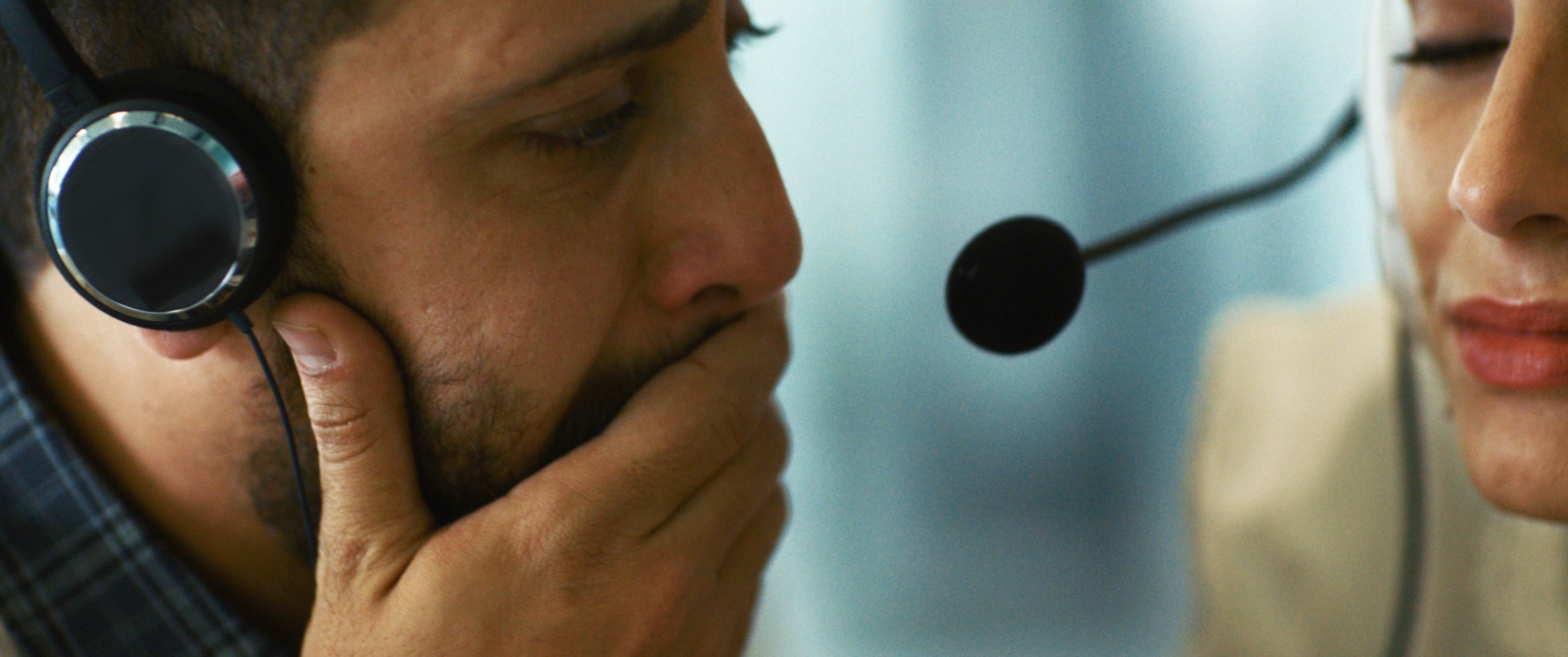 Two individuals wearing headsets are adjacent  together, appearing focused and aggravated  successful  a imaginable  telephone  halfway  oregon  connection  setting