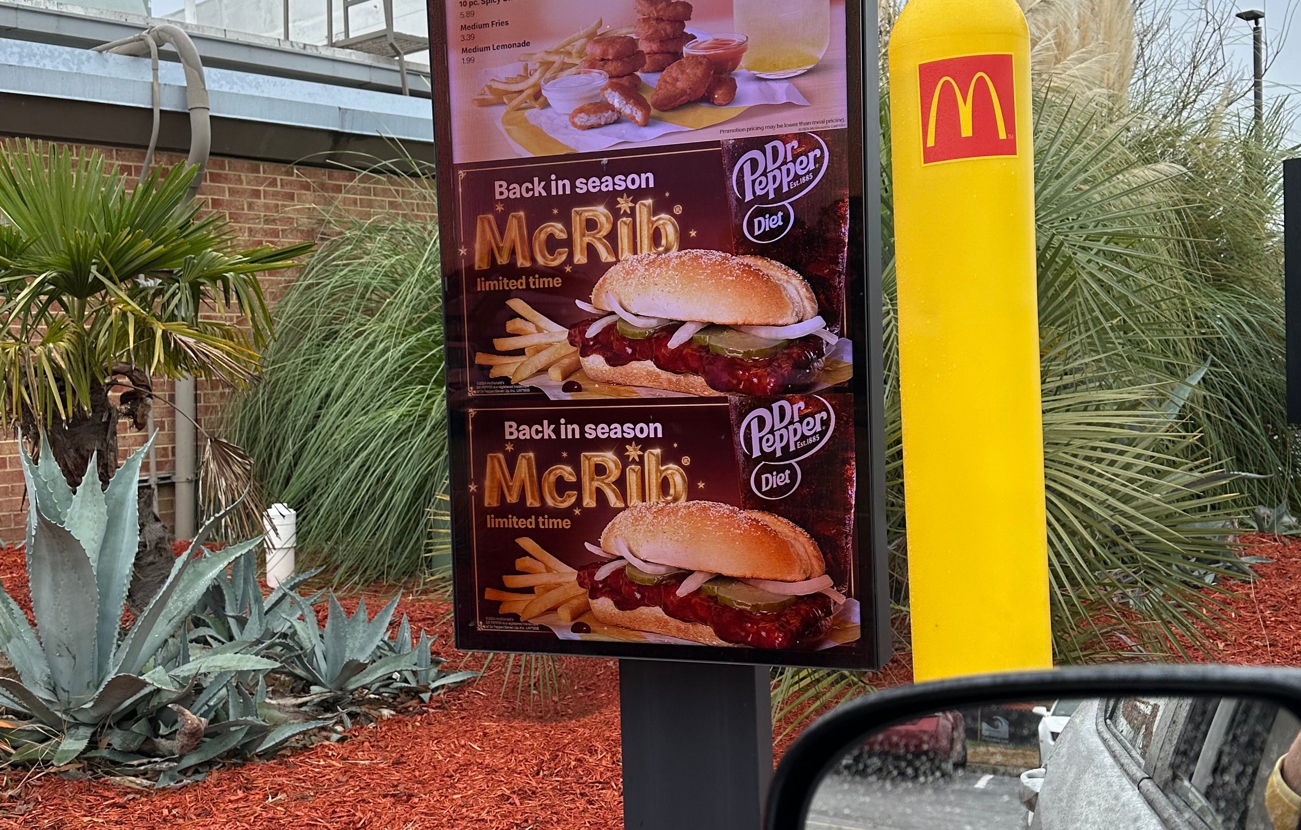 Drive-thru motion   astatine  a fast-food edifice  displays an advertisement  for the McRib sandwich, highlighting its seasonal availability