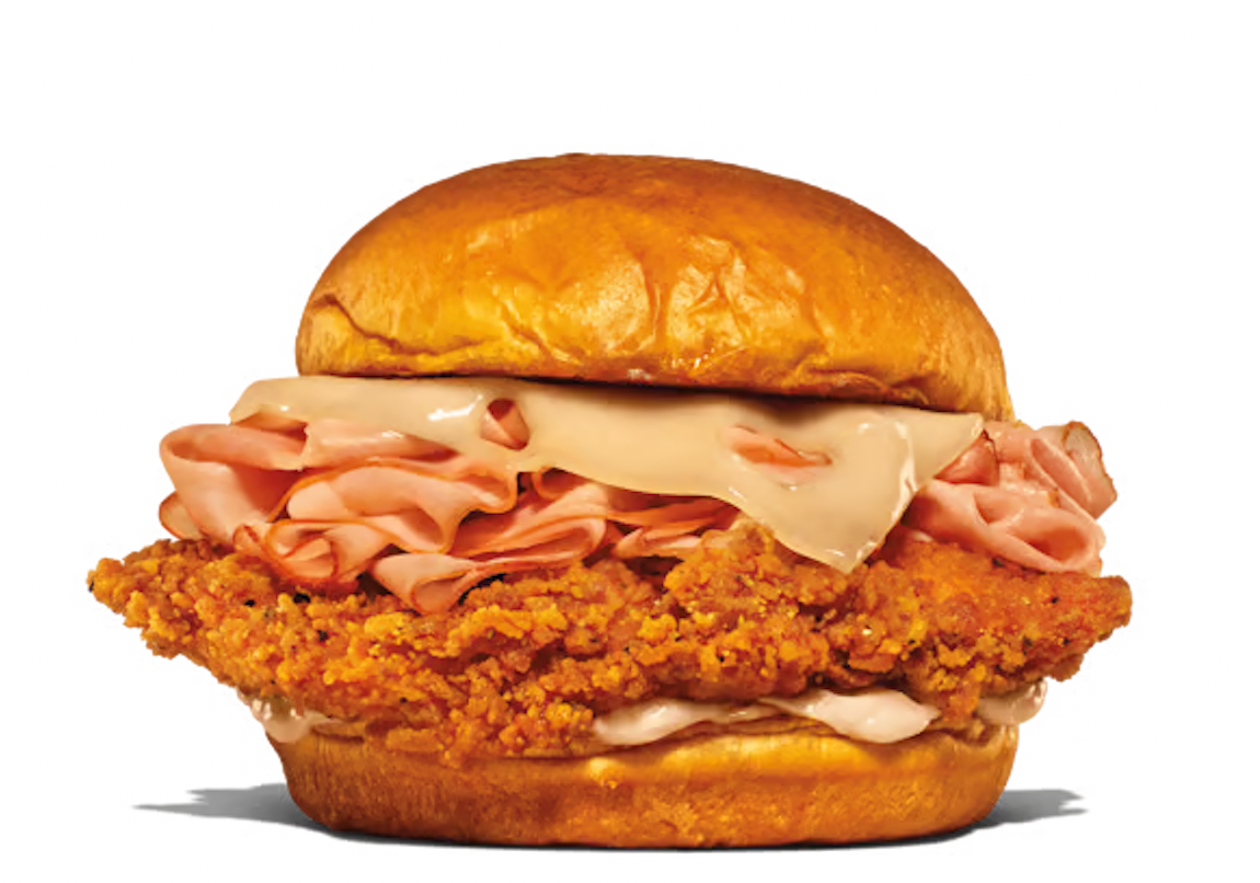 A sandwich with crispy fried chicken, sliced deli meat, and melted food  connected  a brushed  bun