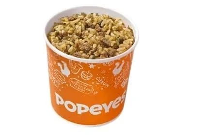 A instrumentality  of Popeyes Cajun rice, filled to the brim, featuring atom   mixed with seasonings and crushed  meats