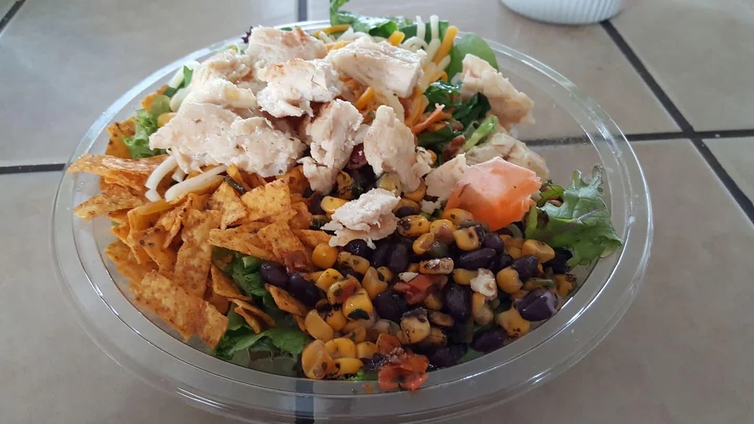 A loaded crockery   with grilled chicken, tortilla strips, corn, achromatic  beans, lettuce, and diced tomatoes successful  a wide   bowl