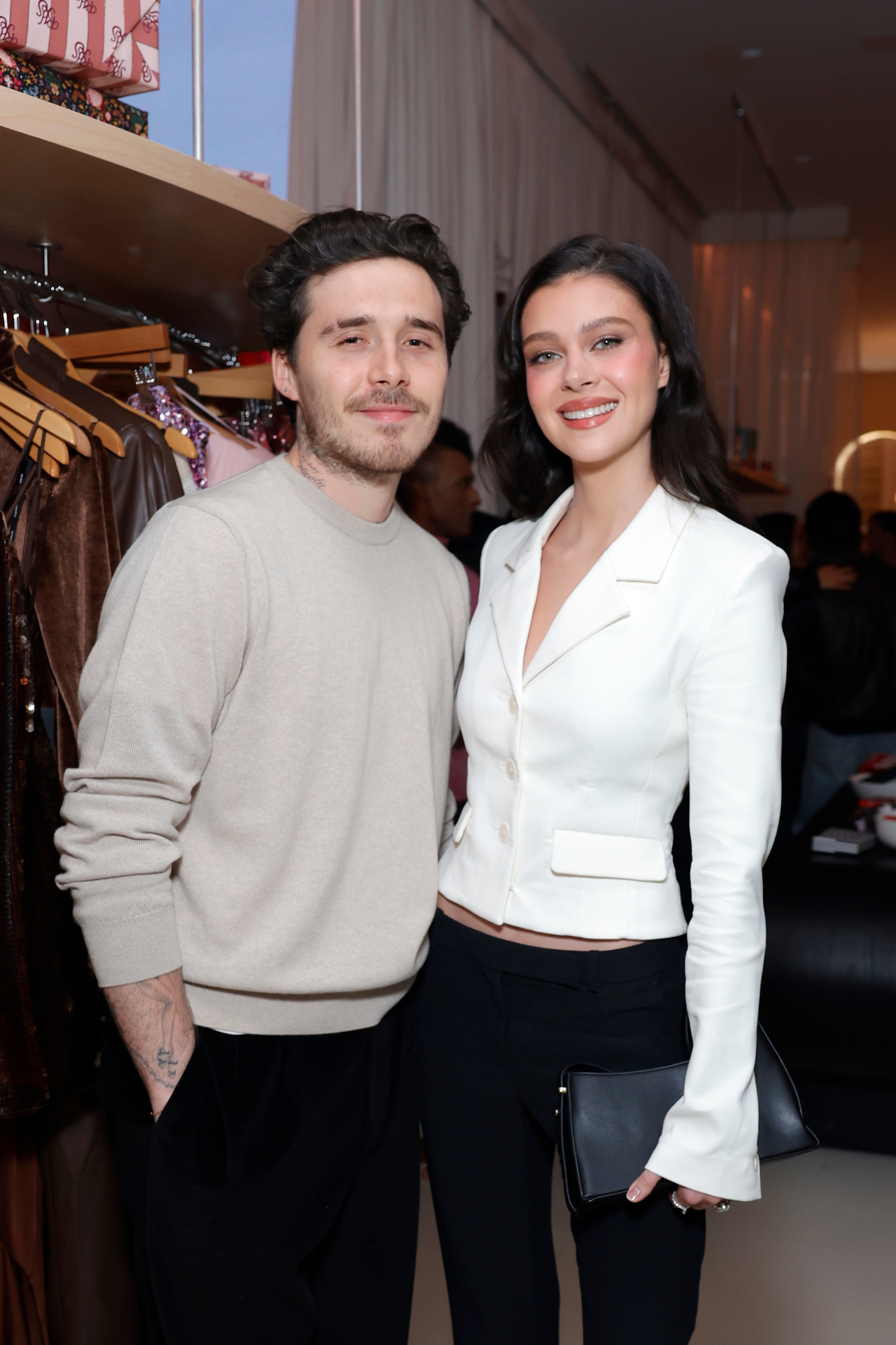 Brooklyn Beckham wearing a casual sweater and Nicola Peltz Beckham successful a stylish tailored blazer, airs unneurotic astatine an event