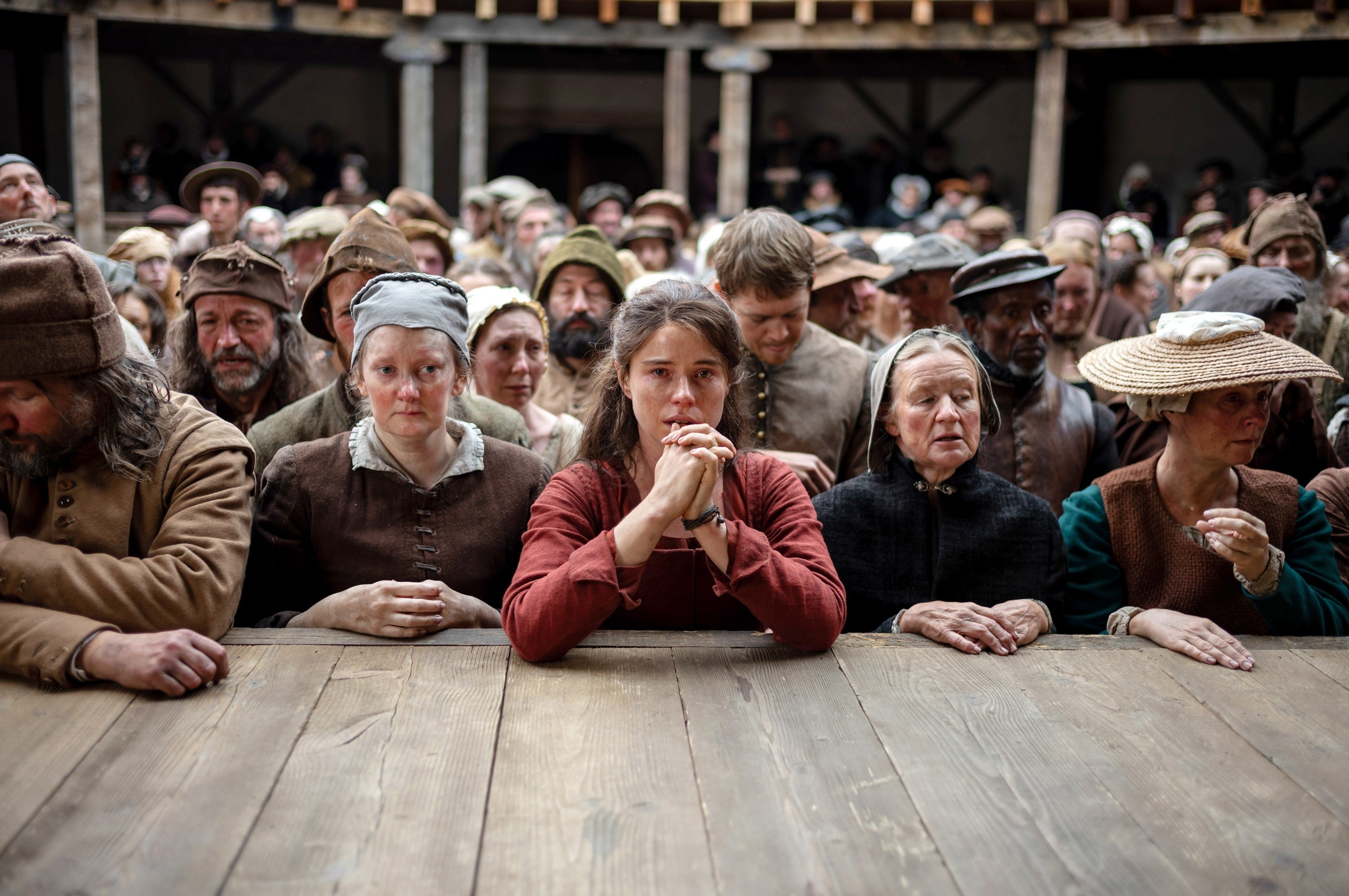 Publikum ser intenst på en historisk gjeninnføring, mange iført tidstypiske kostymer fra 1500- eller 1600-tallet