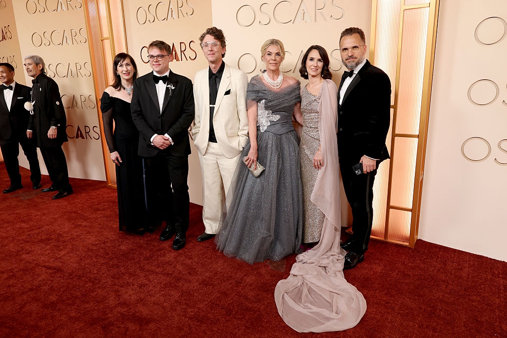 Group of radical   successful  ceremonial  attire connected  a reddish  carpet astatine  an event, with immoderate   wearing tuxedos and others successful  elegant gowns, posing for a photo