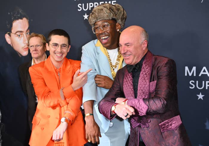 Three radical   successful  stylish suits stock  a laughter  connected  a reddish  carpet