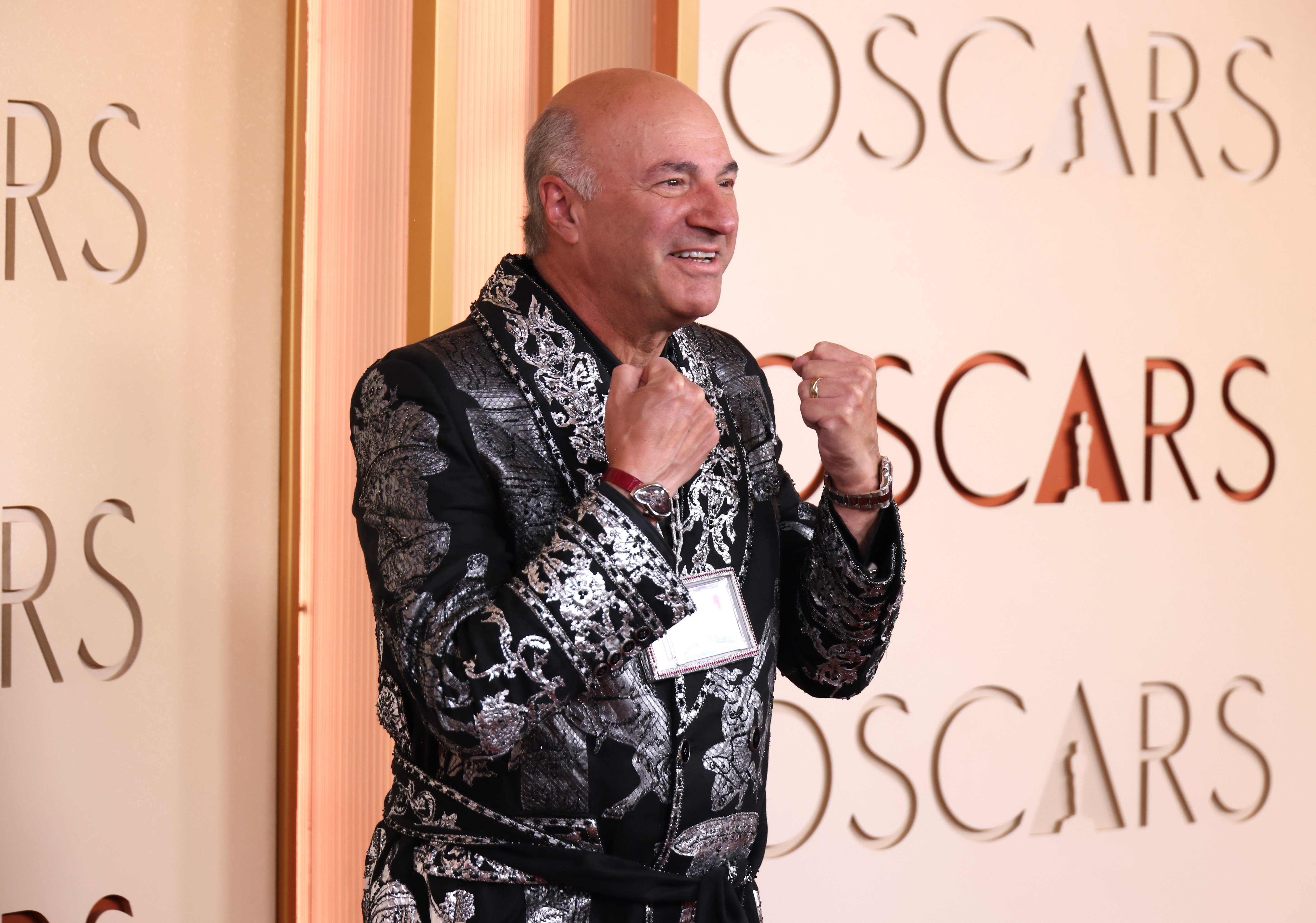A antheral   poses connected  the Oscars reddish  carpet, wearing an ornate patterned jacket