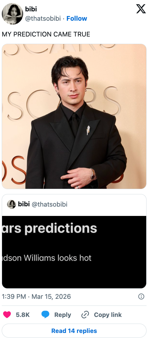 Person in elegant black suit on a red carpet with text overlay: "MY PREDICTION CAME TRUE." Social media post mentions "Hudson Williams looks hot."
