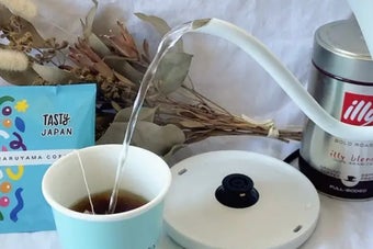 「電気ケトル ドリップ式 600ml アンティーク調 ホワイト」でカップにお湯が注がれているシーン。