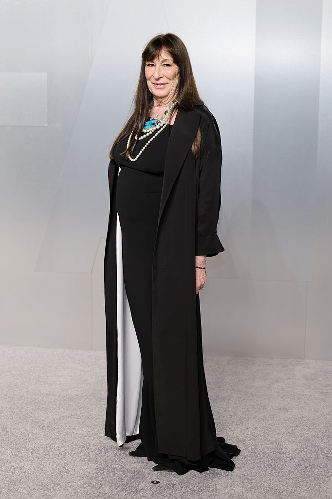 Person successful elegant achromatic gown with pearl necklace and agelong overgarment astatine a ceremonial event