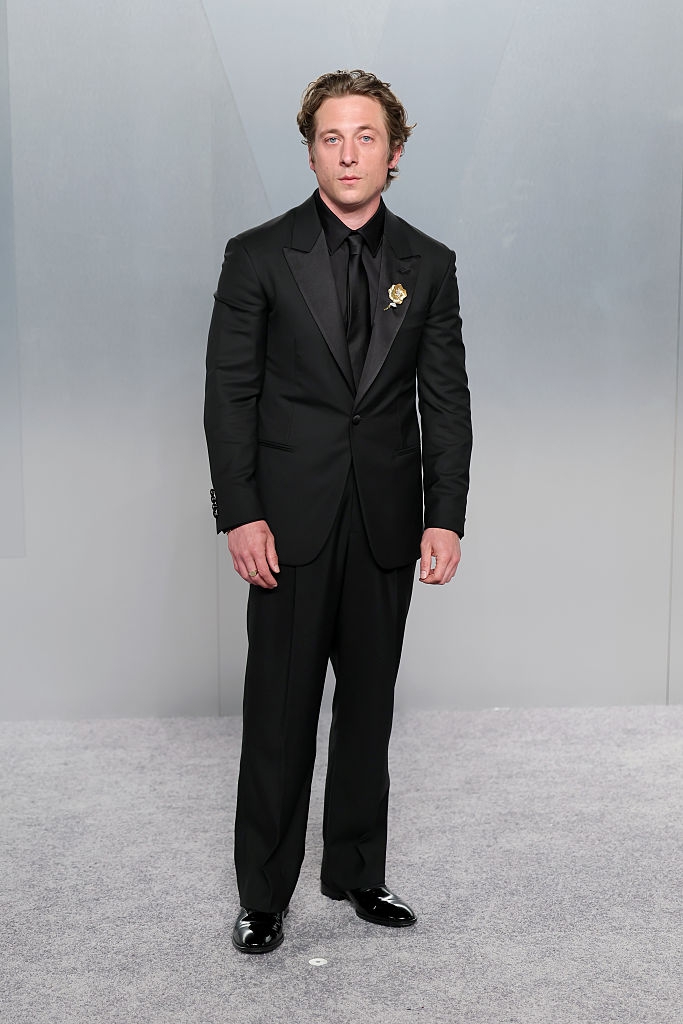 Person successful a sleek achromatic suit with a floral lapel pin, lasting connected a neutral backdrop