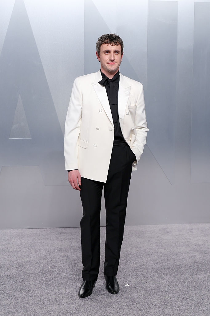 Person successful elegant achromatic double-breasted blazer and achromatic pants connected a reddish carpet astatine a personage event