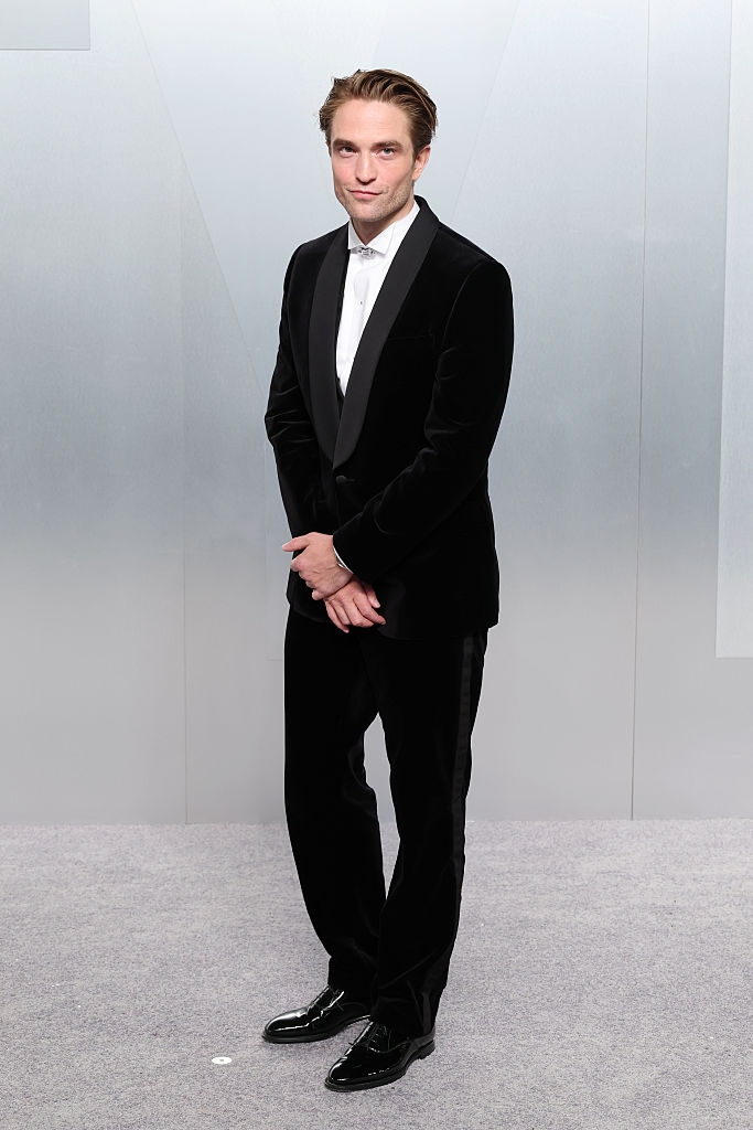 Man successful a classical achromatic tuxedo with a achromatic shirt, lasting connected a grey carpet