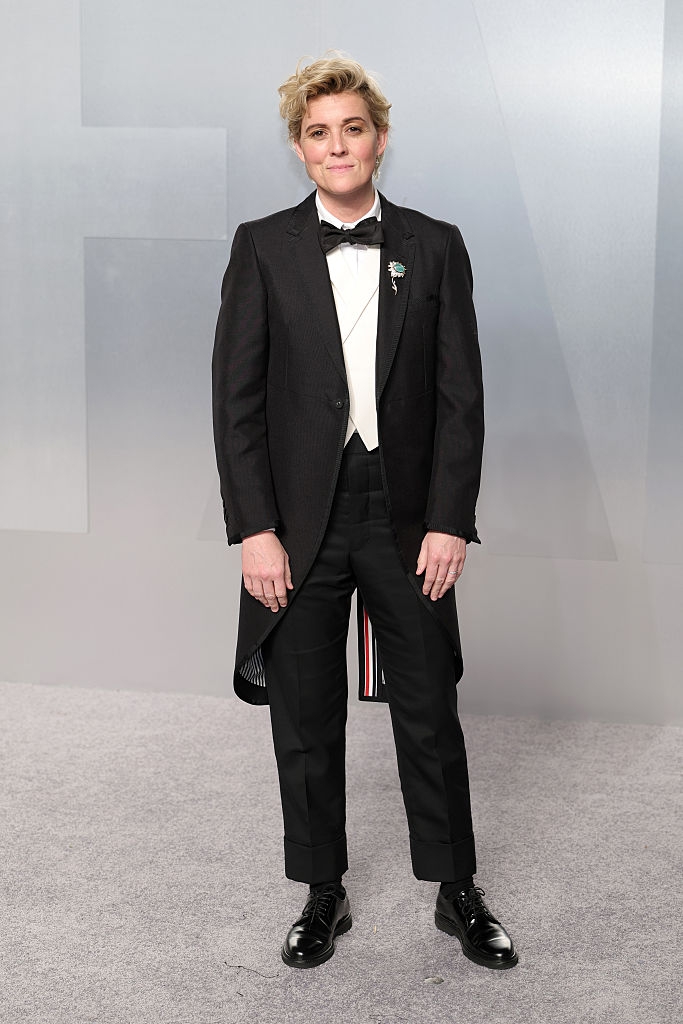 Person successful a stylish tuxedo with a bow necktie connected a carpeted lawsuit floor, hands relaxed by their sides