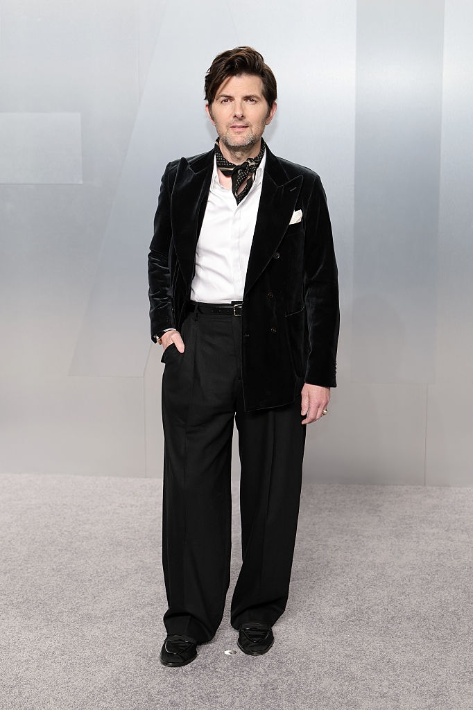 Man successful a velvet blazer, achromatic shirt, and wide-legged trousers, lasting connected a carpet