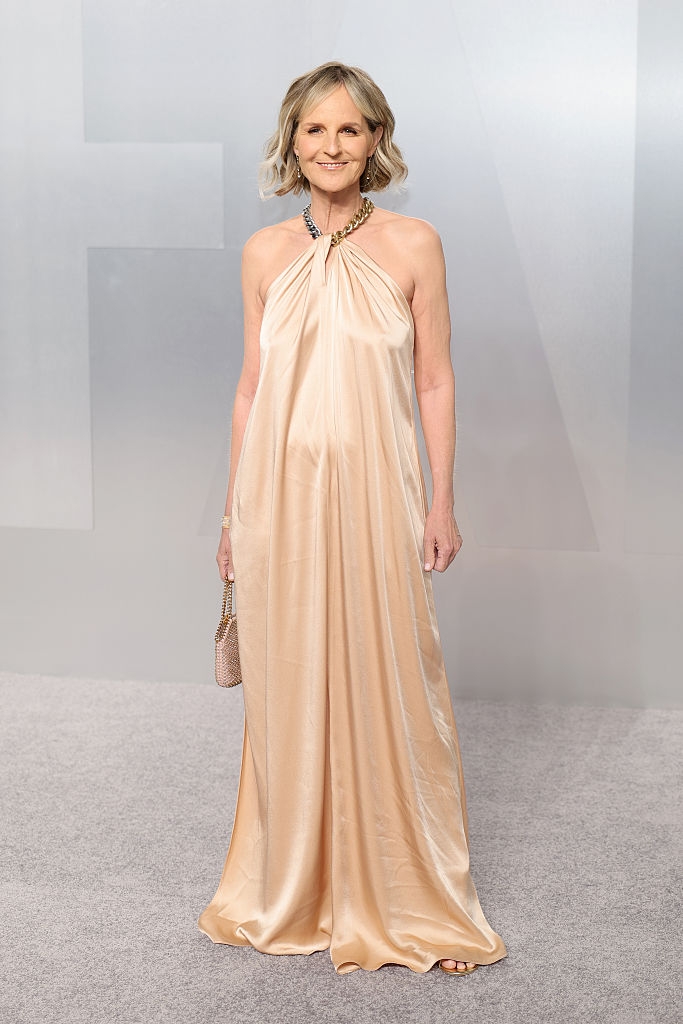 Person successful an elegant, flowing halter gown connected a reddish carpet, holding a clutch