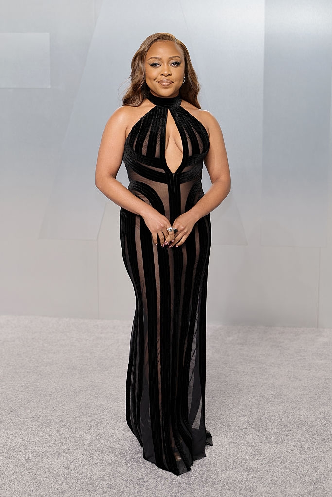 Person successful a stylish, form-fitting gown with geometric cutouts, posing connected a neutral backdrop, exuding elegance and sophistication