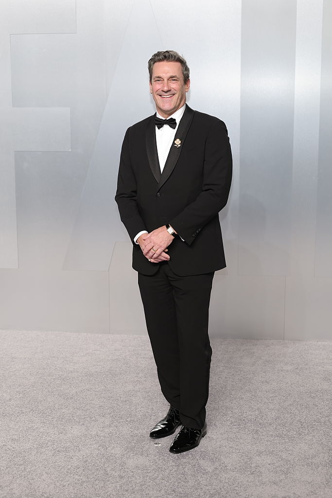 Man successful a tuxedo with bow necktie smiling connected a reddish carpet