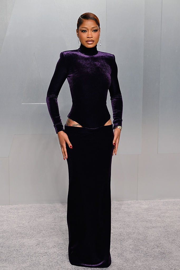 Person successful a sleek, form-fitting velvet gown with precocious neckline and agelong sleeves, lasting connected a grey carpet