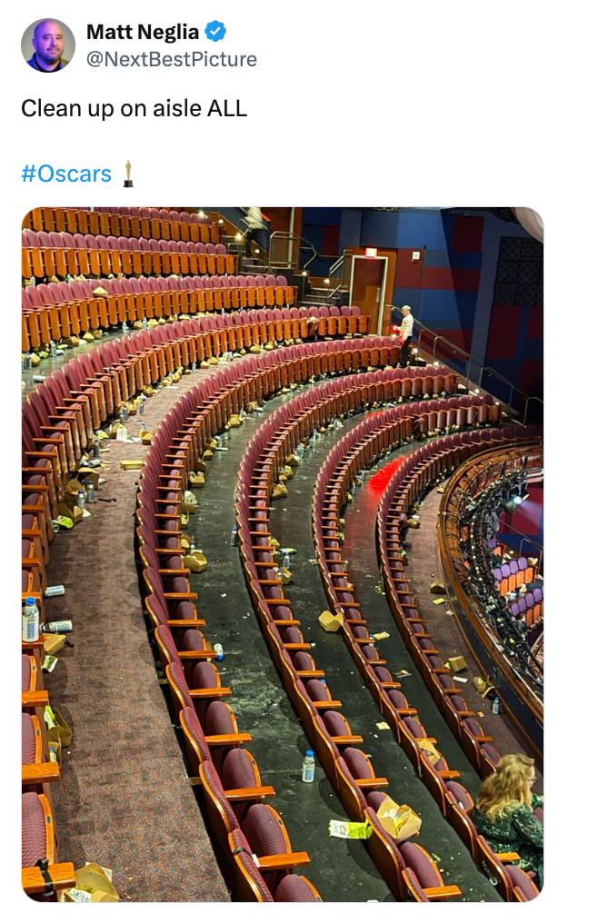 Rows of theatre seats with trash scattered, suggesting a post-event cleanup is needed