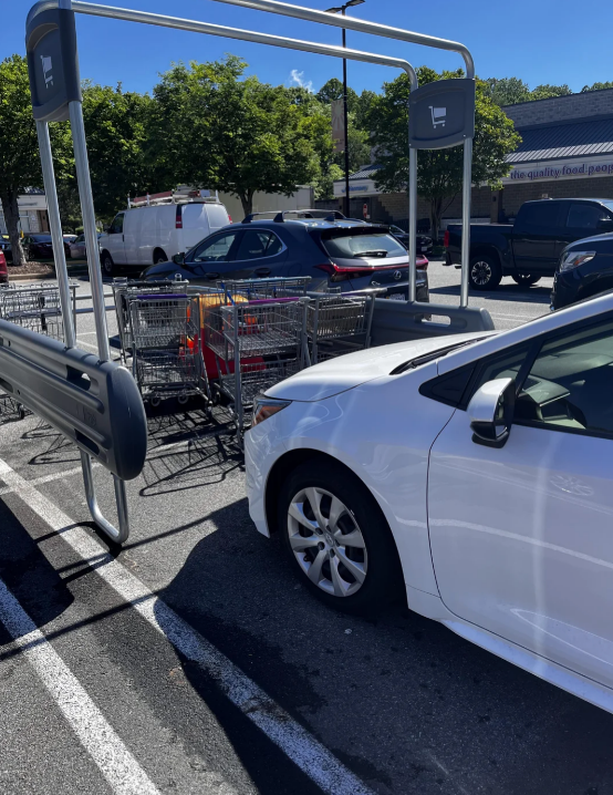 Car parked successful  a buying  cart instrumentality    country  successful  a parking lot, obstructing cart placement