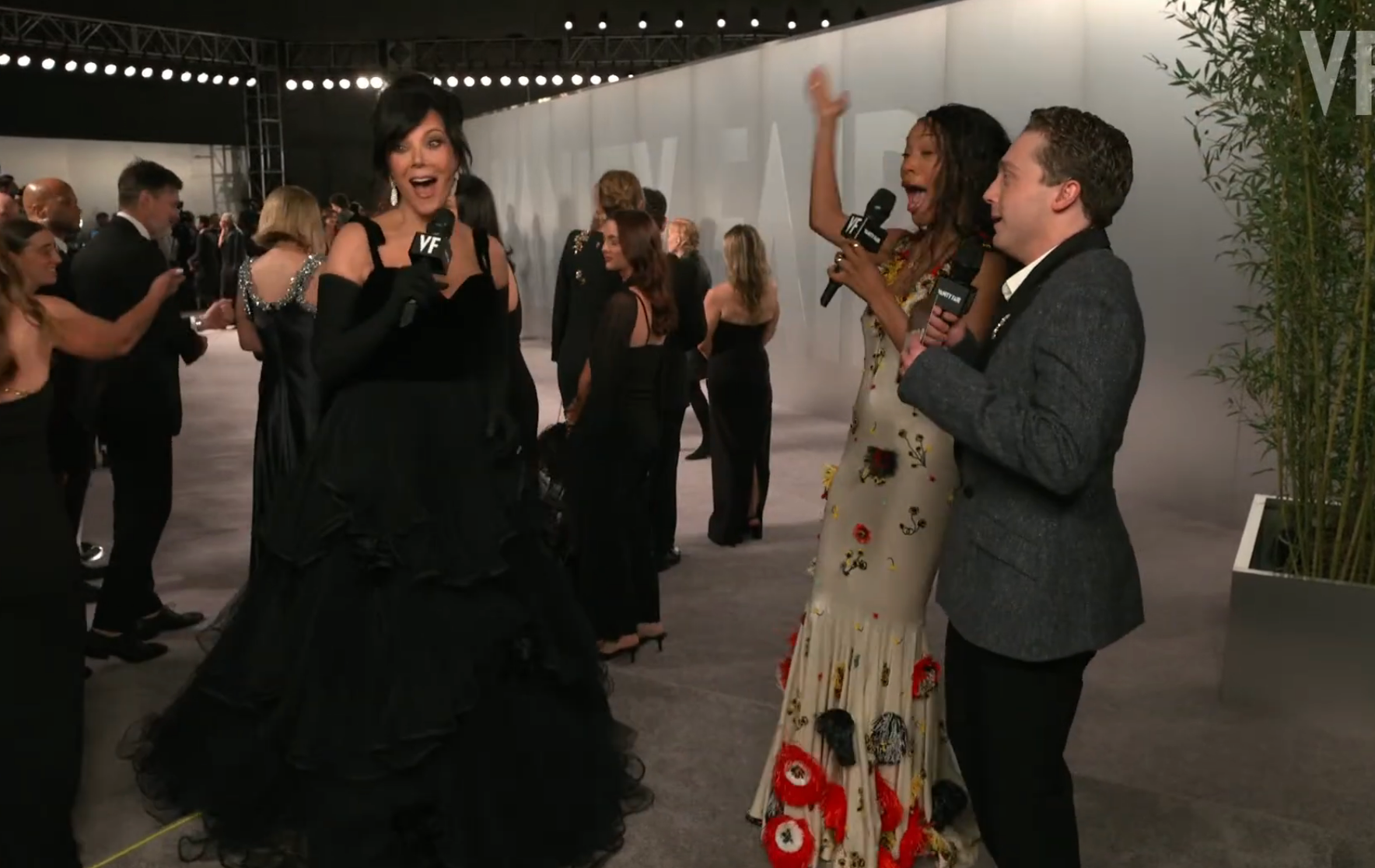 Person successful  melodramatic  gown poses enthusiastically connected  a reddish  carpet, interacting with 2  interviewers holding microphones