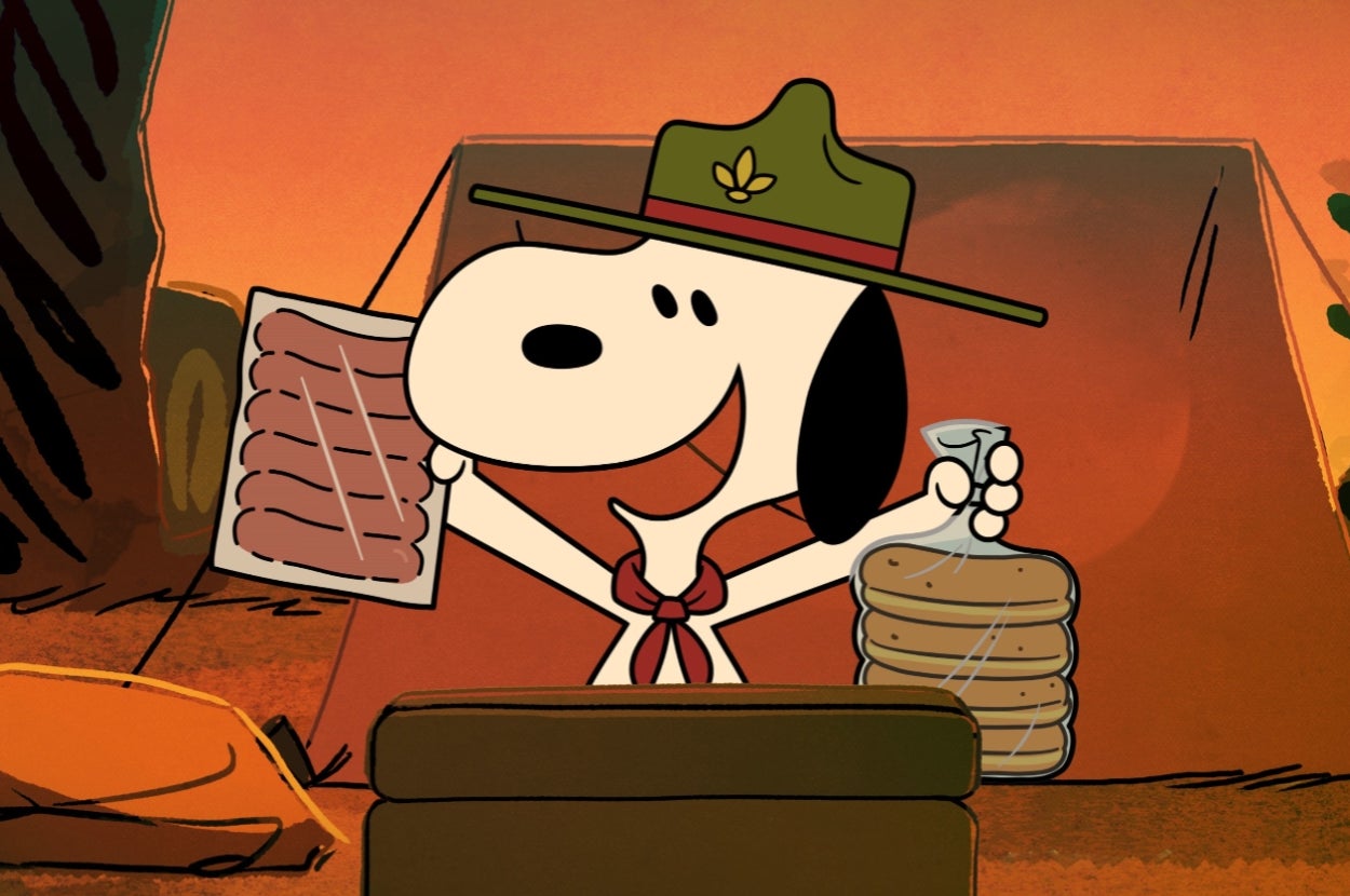 Animated Snoopy in a scout hat and red neckerchief, holding hot dogs and a stack of buns in camping scene