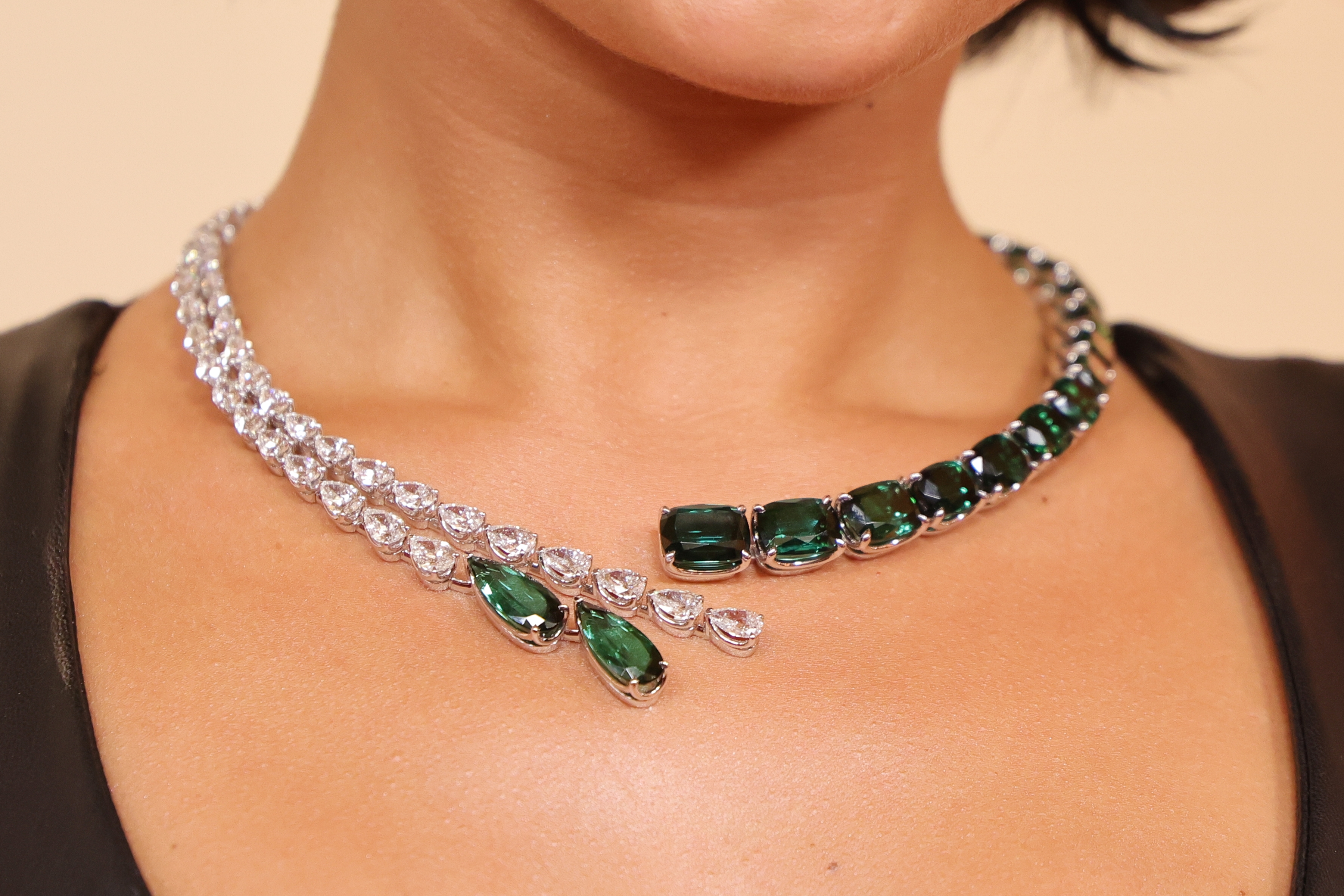Close-up of a idiosyncratic   wearing an elegant necklace with alternating wide   and greenish  stones