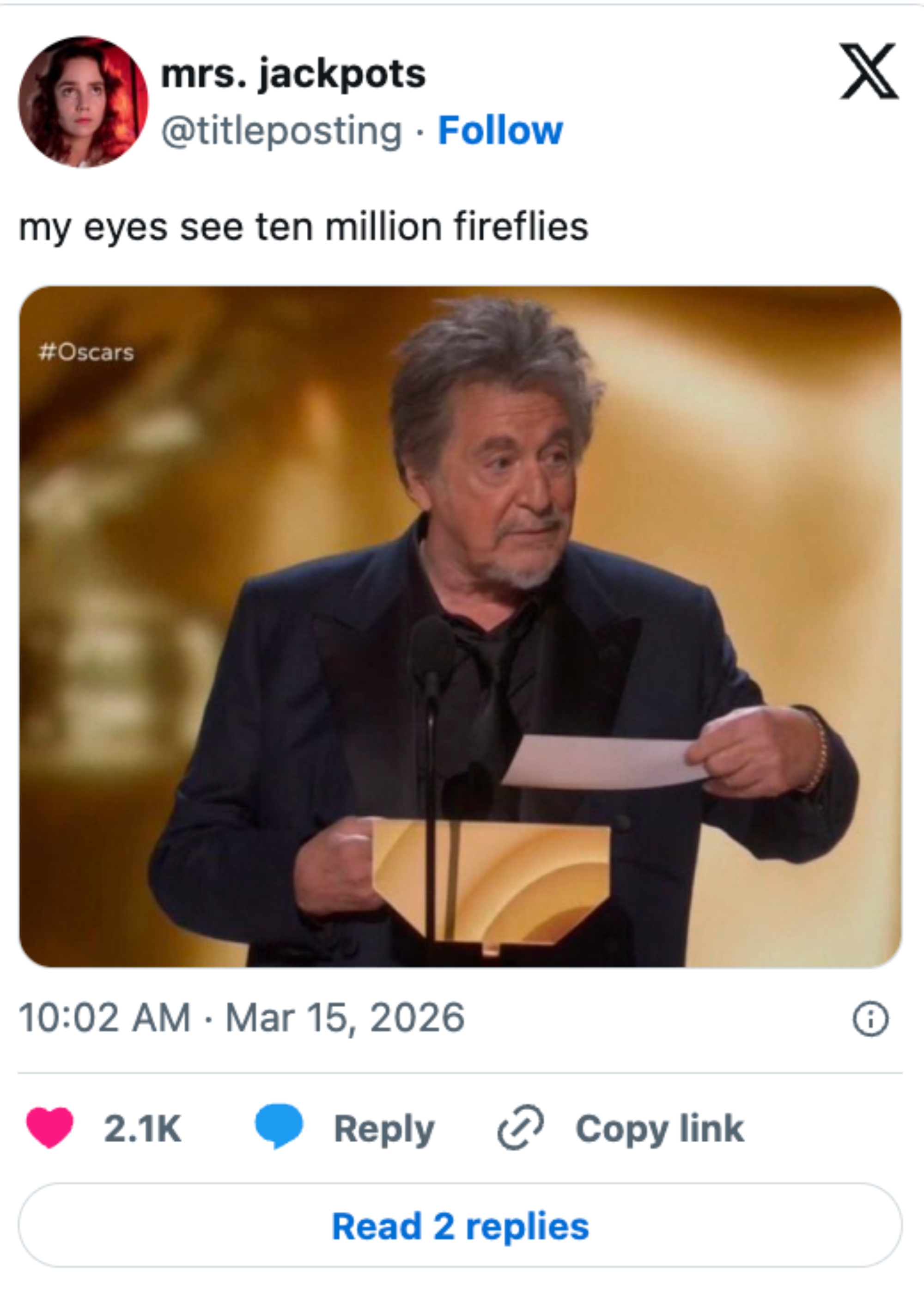 Person on stage in formal suit holding an award and speech at the Oscars. Instagram post comment is visible below