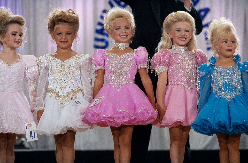 Children successful  sparkly pageant dresses and styled hair, lasting  successful  a enactment     astatine  a contention  oregon  event