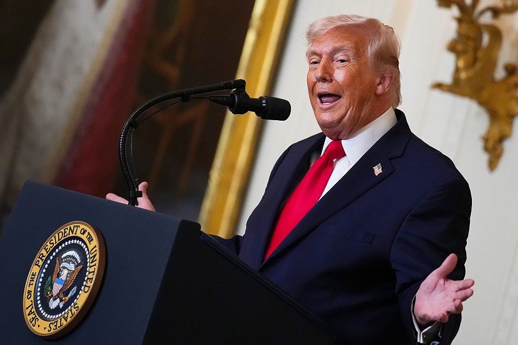 Person på et podium snakker inn i en mikrofon og gestikulerer med åpne hender