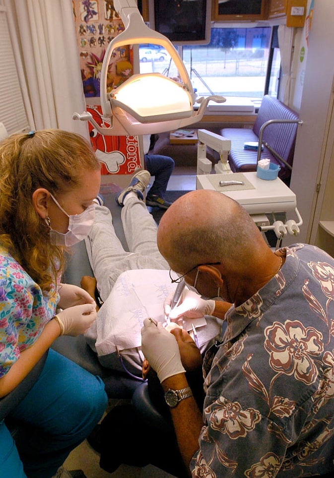 Dentist performs process  connected  a diligent  successful  a clinic, assisted by a hygienist