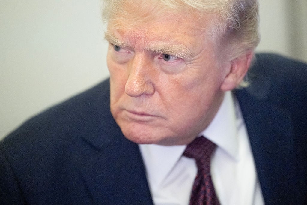 En person i dress med et seriøst uttrykk som ser til siden