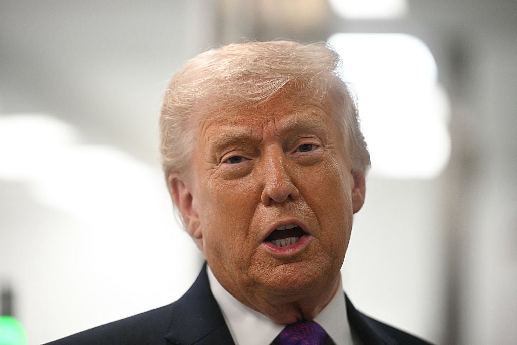 En person i dress og slips snakker i et sterkt opplyst innendørsmiljø