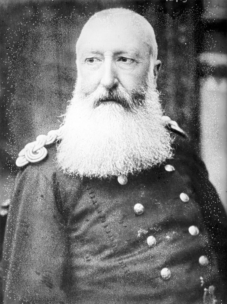 An older antheral   with a agelong  achromatic  beard wears a decorated subject   azygous   with epaulets and buttons