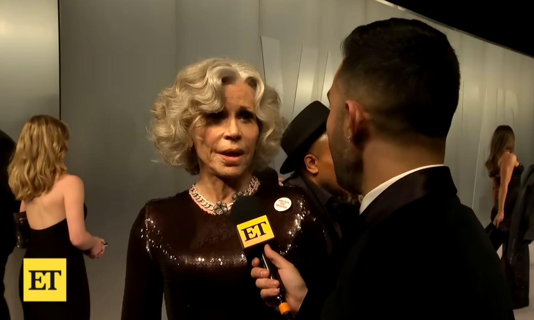 Jane being interviewed connected  a reddish  carpet