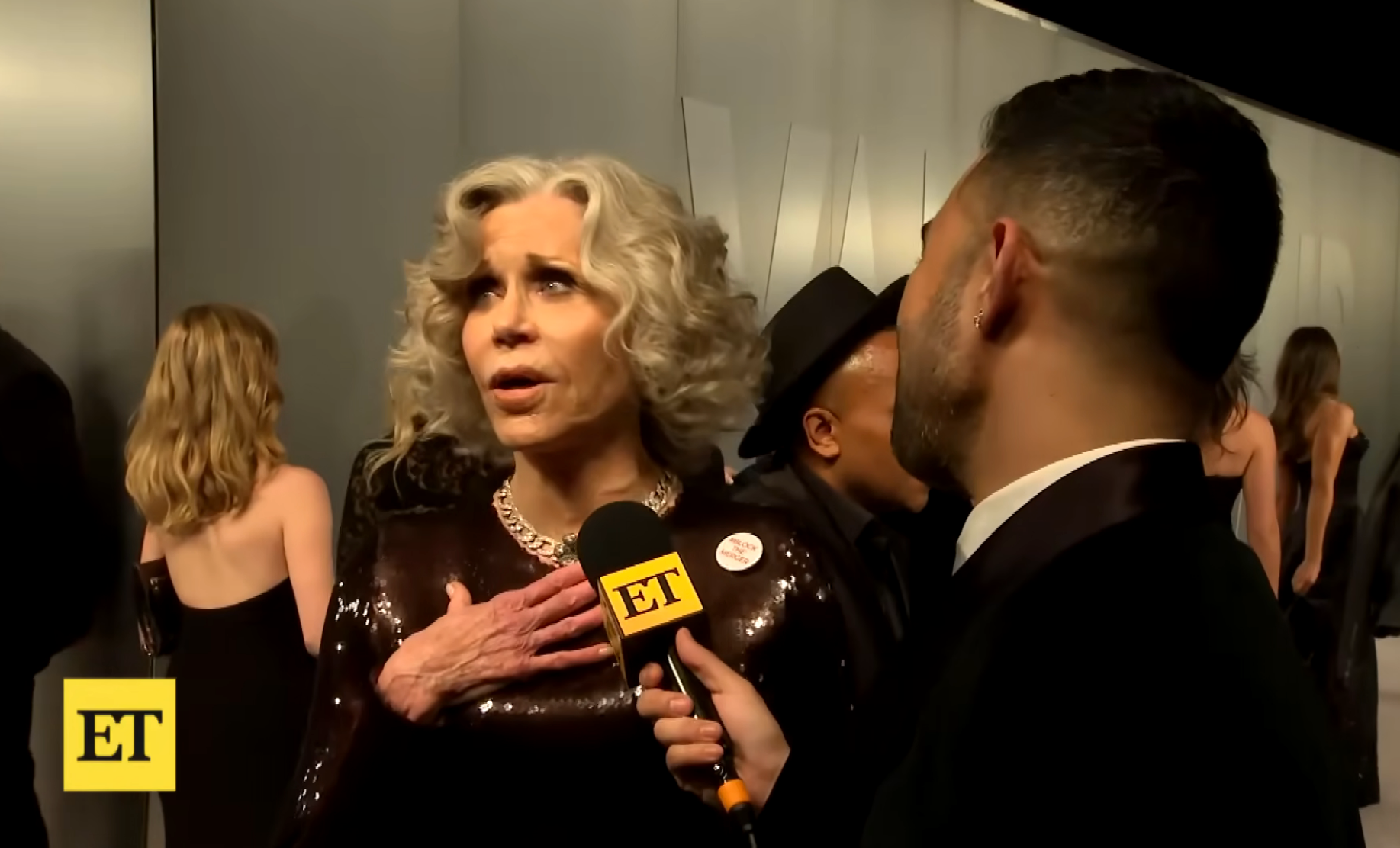 Jane being interviewed connected  a reddish  carpet