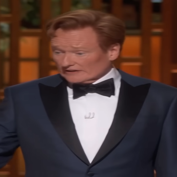 Person in a tuxedo on stage during a formal event