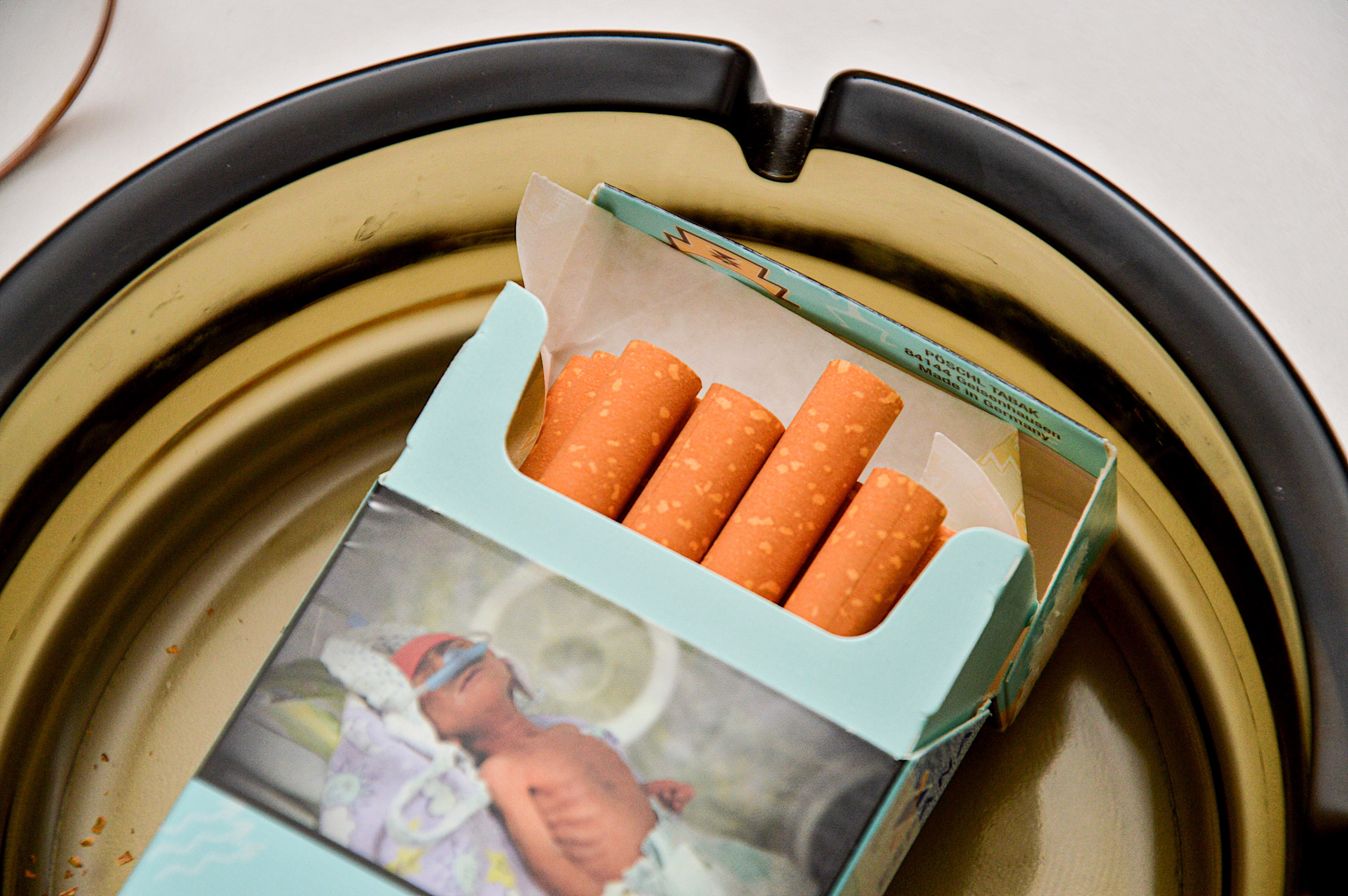 Open container  of Nicola Turkish Tobacco Snuff holding carrot sticks, placed successful  an ashtray