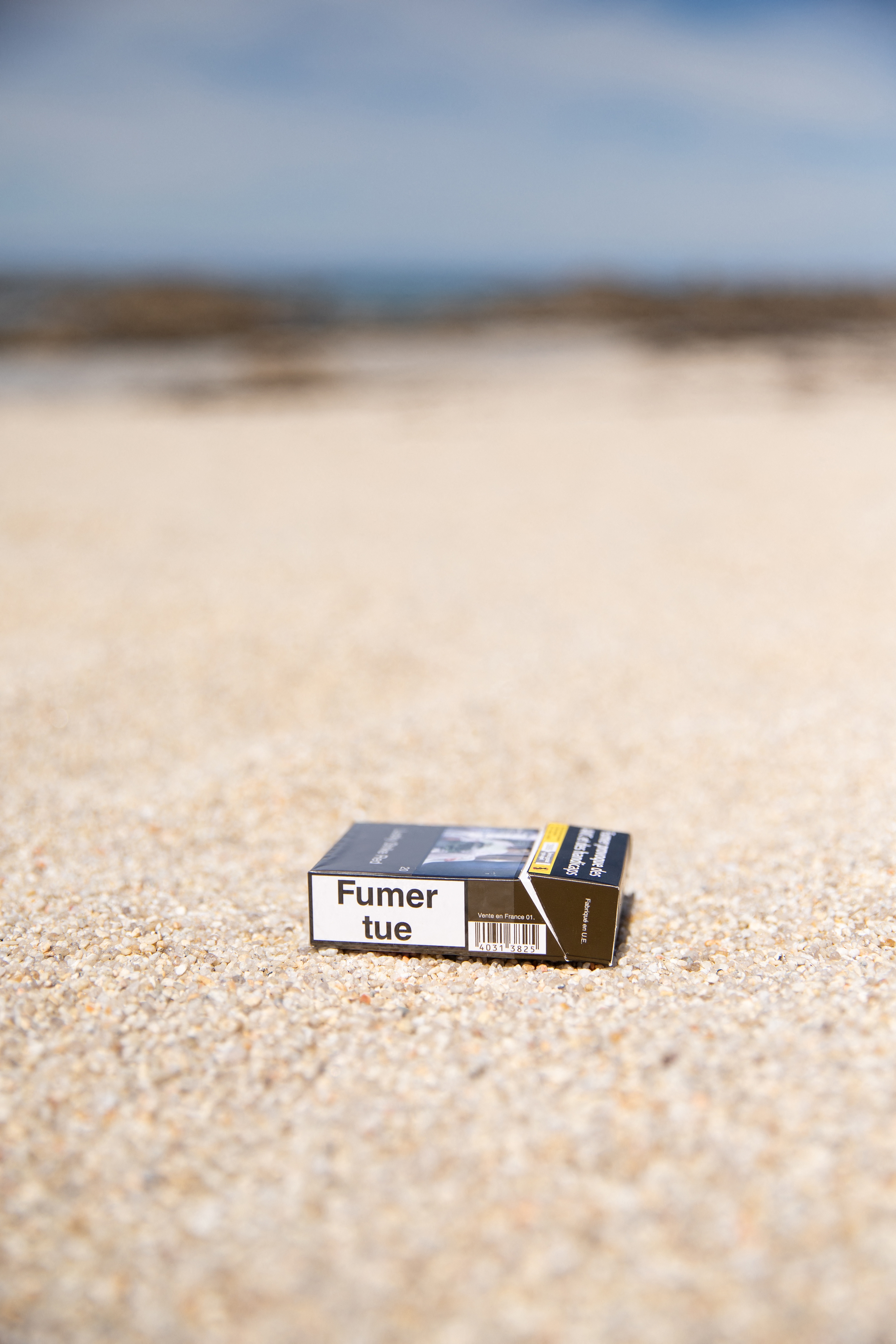 A cigaret  battalion  lies discarded connected  a sandy beach, emphasizing biology  contamination  and littering issues