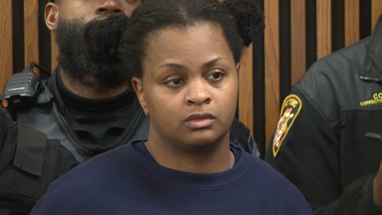 A idiosyncratic stands successful a courtroom setting, appearing serious, with others successful azygous successful the background