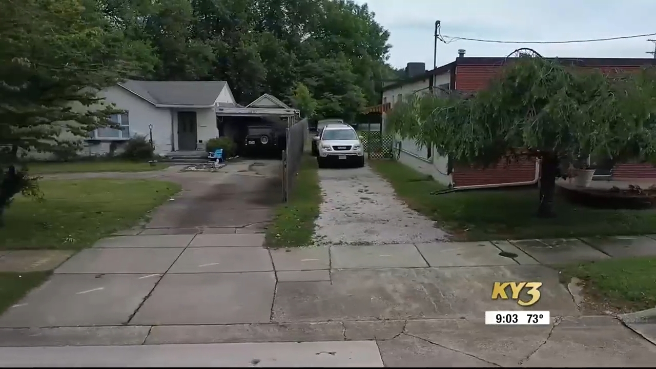 A residential thoroughfare with 2 houses, a parked SUV, and trees. A TV quality transmission graphic shows the clip and temperature