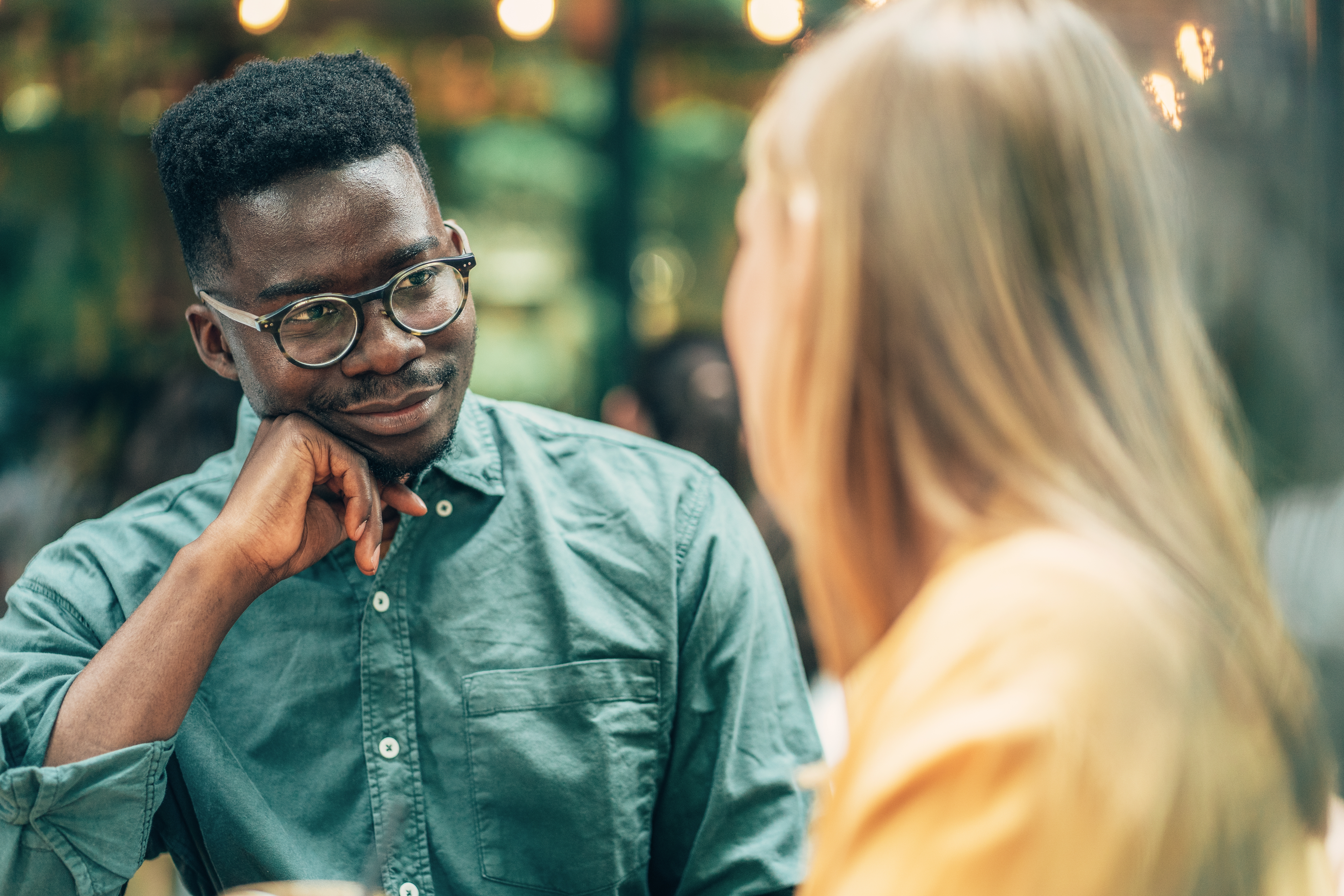 Two people having an intimate conversation at a café. One person is listening intently