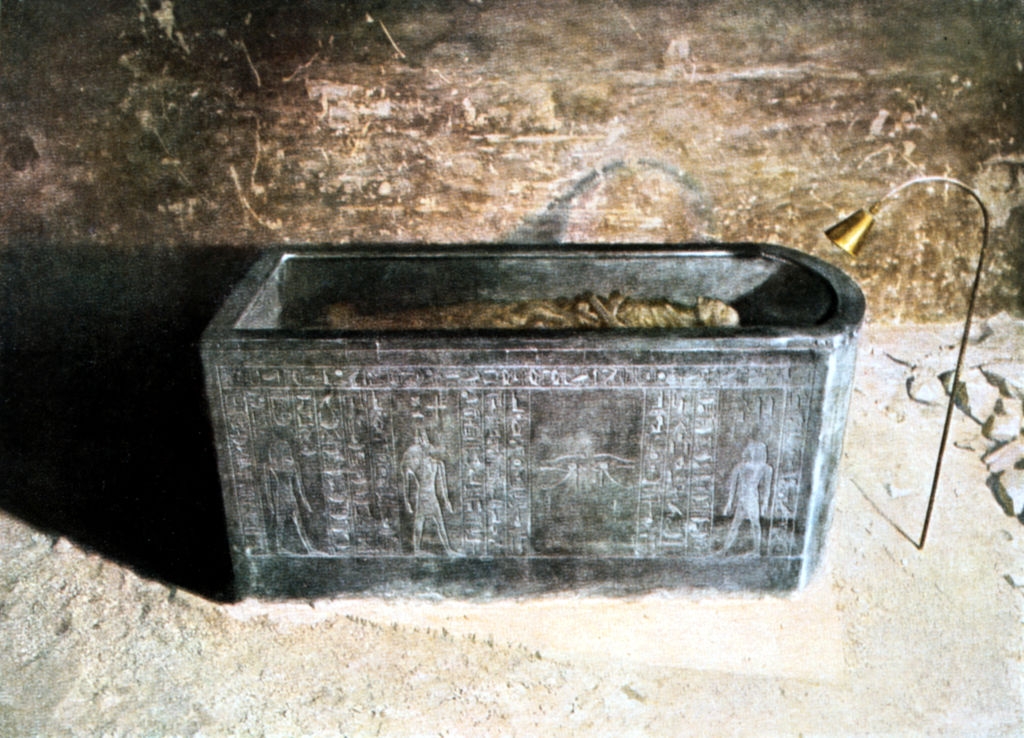 Ancient chromatic  sarcophagus with hieroglyphs, lodging  a wrapped mummy, displayed successful  a dimly lit, aged room