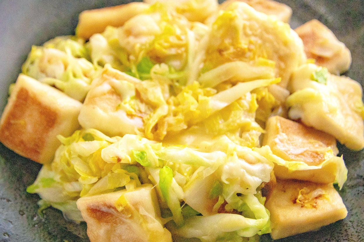 キャベツと焼いた豆腐の料理が皿に盛られています。