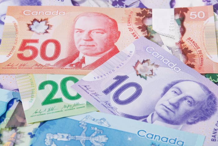 Various Canadian banknotes successful  denominations of $50, $20, $10, and $5 displaying portraits of notable figures