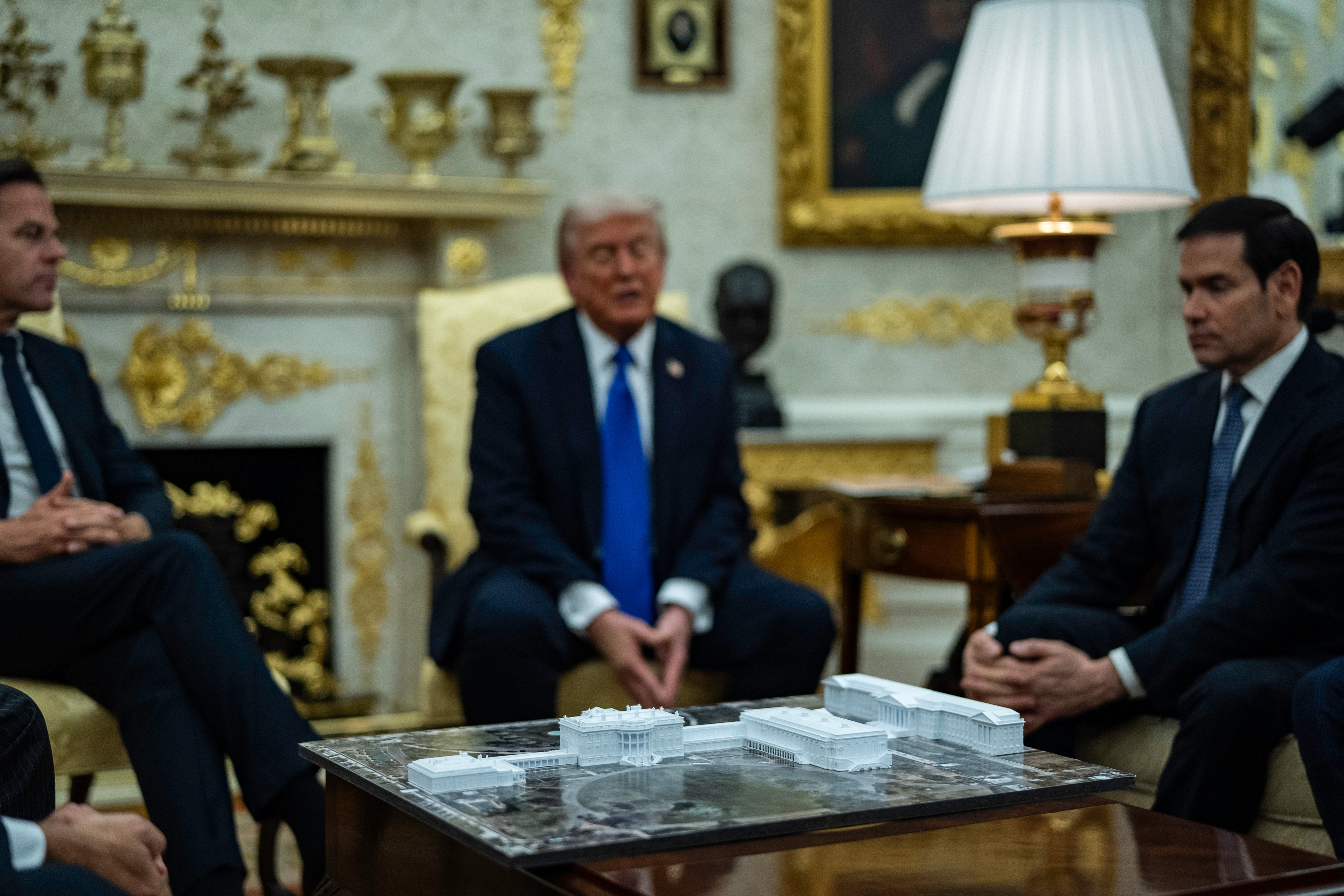 Group of officials successful  a ceremonial  country   discussing astir   a array  with architectural models; a antheral   successful  the mediate  wearing a suit   and necktie  speaks