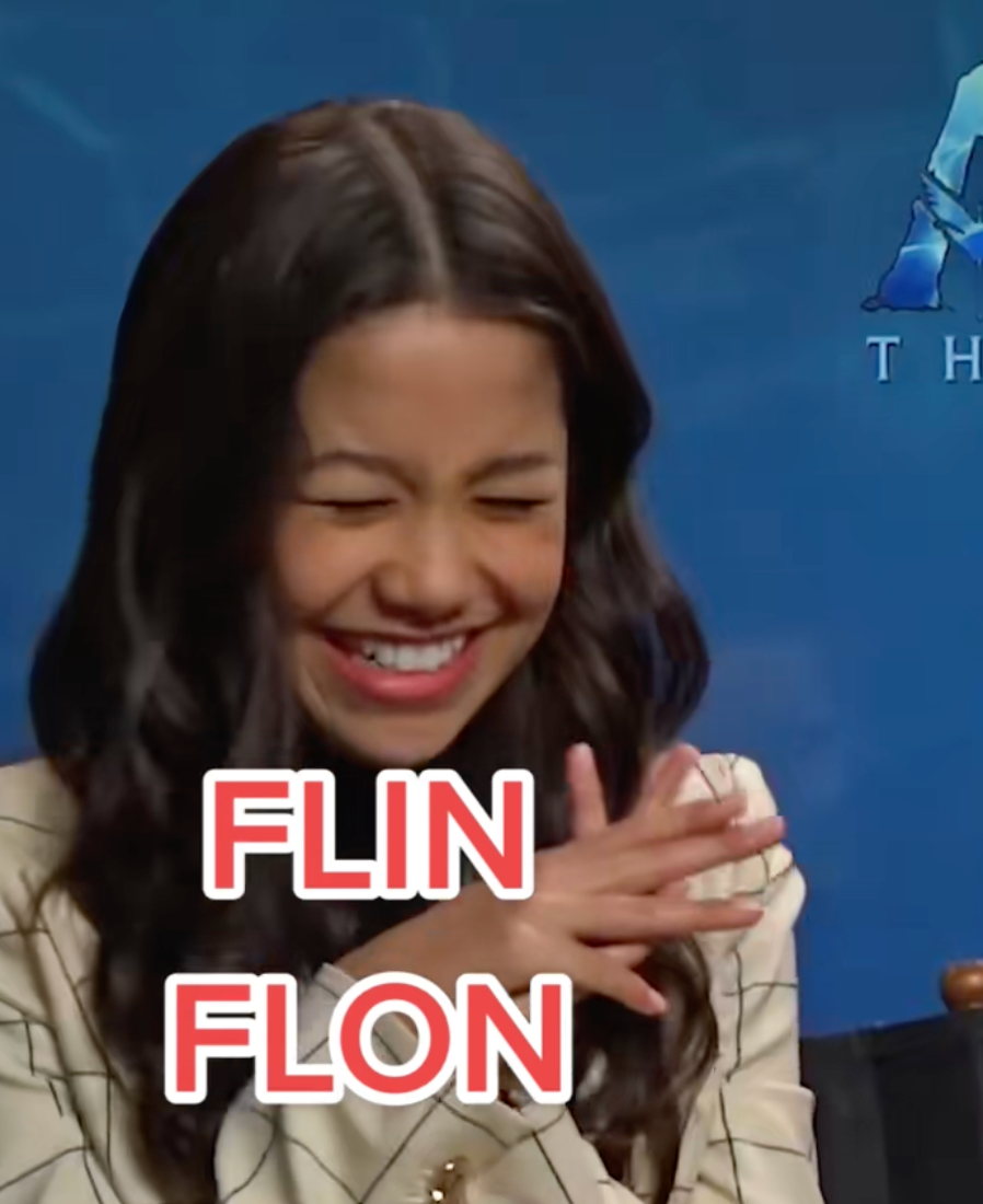 Person laughing and crossing their arms, wearing a patterned jacket. The substance   reads "FLIN FLON."